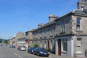 Terraced houses and parked cars in the village of Roslin