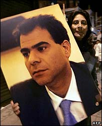 زنی در بیروت پوستر پی یر جمیل را در دست دارد