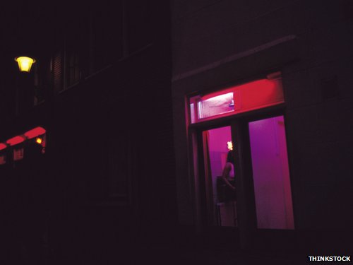 A woman in a room, lit by a red light