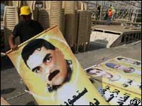 Operário segura cartaz do Hezbollah mostrando o prisioneiro libanês Samir Qantar