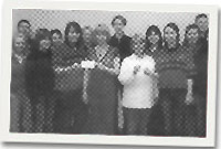 Swyddogion ac aelodau'r clwb yn cyflwyno siec o £750 i Nyrsus Cymunedol Aberaeron a Chei Newydd.