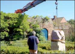 Crane lifting the stone into a garden.