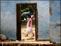 Mulher passa por casa destruída pelas ondas gigantes no Sri Lanka