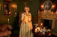 Lucy Worsley in costume standing in a living room