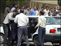 مردم در حال انتقال يکی از مجروحان به داخل يک خودرو