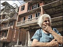 Lady outside damaged building in Gori, Sout Ossetia