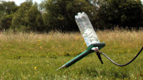 The bottle resting in the launcher with pump attached