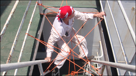 Crew member Oleg Kahanakeav puts up ropes to stop pirates boarding the Boularibank 
