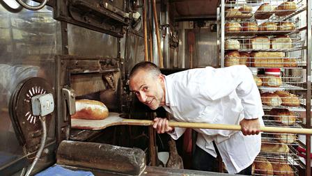Michel Roux Jr removing bread from a traditional baker's oven.