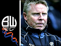 Sammy Lee bên cạnh logo của Bolton Wanderers