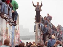 Crowds celebrate on the Berlin Wall after a section of it has been knocked down