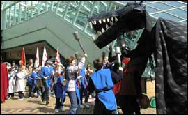 Children in Coventry City Centre act out a fight with a dragon 