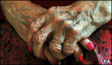 An older person with clasped hands
