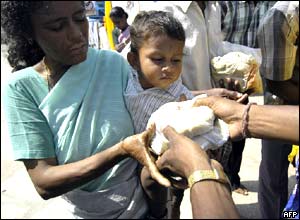 Indická žena a dítě dostávají potraviny