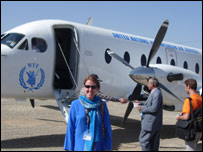 Monica Villarindo ao lado de um avião da ONU
