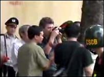 An ninh vây quanh phóng viên Ben Stocking khi ông chụp hình tại phố Nhà Chung