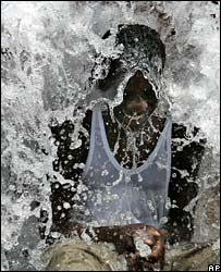 Jovem se refresca com água de hidrante
