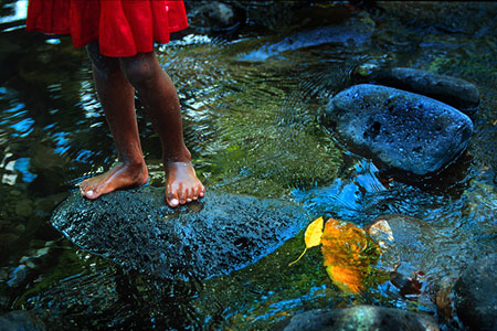 Girl in a red dress standing on a rock, photo by Tom Ang