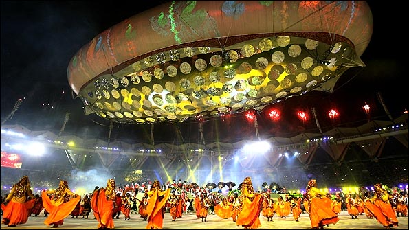 Entertainers perform underneath a giant aerostat at the Jawaharlal Nehru Stadium