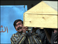 مردی حامل یک تابوت در مرده شوی خانه بغداد