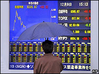 Homem observa painel eletrônico da bolsa de Tóquio