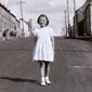 Anne on Old Orritor Street, circa 1953. Anne's house is second from the left in the background. This was the window she looked through at the Christmas tree from the story