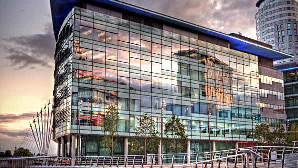 glass-fronted office building by a canal