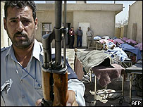 نگهبان عراقی و اجساد کارگران ساختمانی پشت سرش