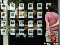 顾客在地产商橱窗看房屋资料