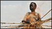 Former child soldier carries wood to the fire in South Sudan