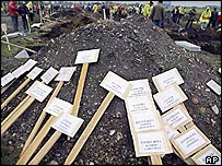 Biển đánh dấu mộ tạm thời ghi tên tuổi và ngày mất của các nạn nhân