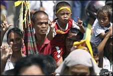 Mourners watch as Aquino's body is taken through the streets of Manila