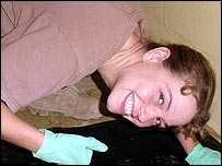 A soldada Sabrina Harman posa ao lado de corpo de preso iraquiano morto em Abu Ghraib