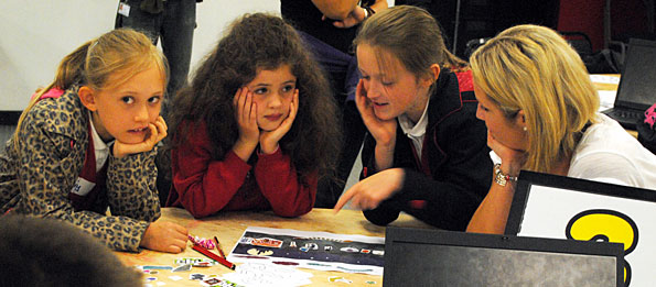 Girls poring over paper prototypes at a table