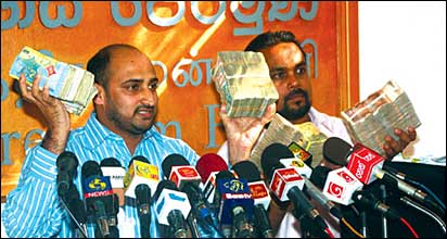 Wimal Weerawansa and Mr. Muzamil showing off money reportedly given to Mr. Muzamil (photo: Lake House)