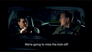 Two men in a car sign that they're going to miss the super bowl kick off
