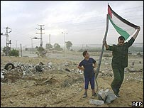 Palestinos colocam bandeira perto da principal estrada de Gaza