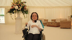 Liz Carr surrounded by flowers