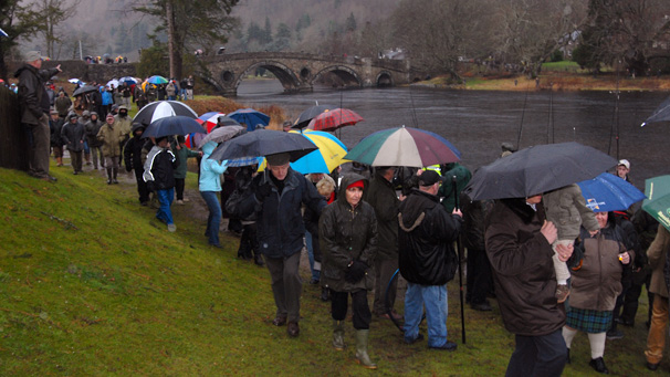 Crowd gathered along river bank