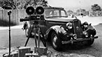 Image of a car and film shoot set-up from the 1950s