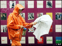 Chinês tenta abrir o guarda-chuva em Xangai