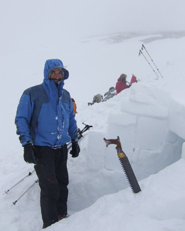 Mountaineer with snow saw, building snow-hole