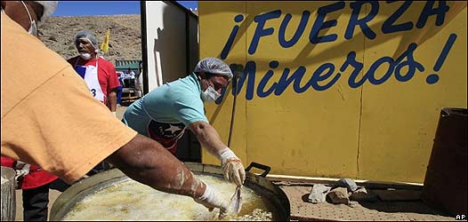 Hombres frien pescado en el campamento de la mina de San José