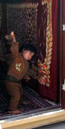 A child in prison in Helmand province beating a carpet