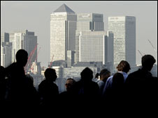 City workers silhouetted in front of Canary Wharf's skyline