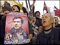 Manifestantes carregam poster do líder da oposição Mikhail Saakashvili