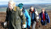 Four people walking between rolling heather