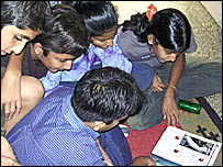 بچے جریدے کے نئے شمارے پر جھکے ہوئے ہیں