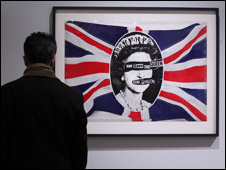 A man looking at the punk artwork God Save the Queen