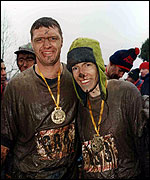 Two people, covered in mud.